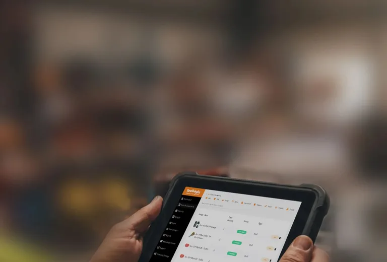 Work-gloved hands running a ToolLogix report on a tablet in the shop